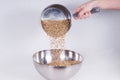 Caramel malt spilled from a stainless ladle into a bowl. Craft b