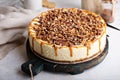 Caramel pecan cheesecake topped with chopped nuts