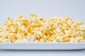 Caramel popcorn grains on the white dish and white background
