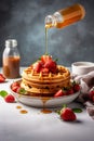 Caramel pouring on freshmade waffles with strawberries. Breakfast with Belgian waffles. Vertical