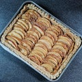 Caramelised apple pie in a square aluminium tray