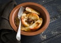 Caramelized apples with cinnamon and honey in a clay dish