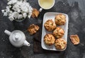 Caramelized cinnamon apples muffins, green tea, bouquet of chrysanthemums on a dark background, top view. Dessert table Royalty Free Stock Photo