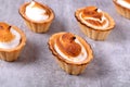 Caramelized Italian meringue in shortbread tartlets on gray table. Royalty Free Stock Photo