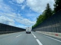 Caravan on Austrian highway with bridge and noise barrier. Innsbruck, Austria, 12.05.2023.