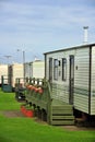 Caravan camp on green grass under clouds Royalty Free Stock Photo