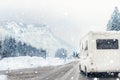 Caravan or campervan turning from road with beautiful mountain alpine landscape on background at cold winter season.Family Royalty Free Stock Photo