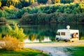 Caravan camping on lake shore with satellite dish on roof Royalty Free Stock Photo