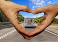 Caravan car on the road love travellng hands fingers like heart  a love background Royalty Free Stock Photo