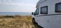 Caravan car by the sea in summer beach trees blue sky Royalty Free Stock Photo