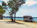 Caravan car by the sea in summer beach trees blue sky Royalty Free Stock Photo