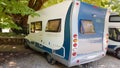 Caravan car under tree shadow leaves green nature by the river Royalty Free Stock Photo