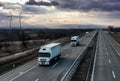 Caravan or convoy white lorry trucks on country highway Royalty Free Stock Photo