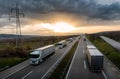 Caravan or convoy of white trucks on highway