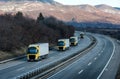 Caravan or convoy of Yellow lorry trucks on country highway Royalty Free Stock Photo