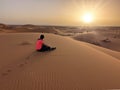 A caravan of dromedaries passing the Sahara desert in the evening