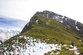 A caravan of mountaineers climbing a beautiful green mountain with snow and blue sky. Pico Penaboa, Courel, Galicia Royalty Free Stock Photo