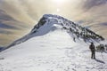 A caravan of mountaineers climbing a beautiful mountain with snow and sun rays. Pico Pia Paxaro, Courel, Galicia Royalty Free Stock Photo