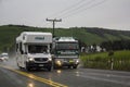 Caravan overtaking truck on wet road