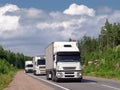 Caravan of white trucks on highway