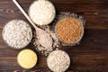 Carbohydrates. Various grain flakes in bowls on wooden. Oat, corn, rice, buckwheat, rye and wheat flakes. Royalty Free Stock Photo