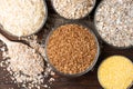 Carbohydrates. Various grain flakes in bowls on wooden. Oat, corn, rice, buckwheat, rye and wheat flakes. Royalty Free Stock Photo