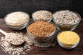 Carbohydrates. Various grain flakes in bowls on wooden. Oat, corn, rice, buckwheat, rye and wheat flakes. Royalty Free Stock Photo