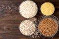 Carbohydrates. Various grain flakes in bowls on wooden. Oat, corn, rice, buckwheat, rye and wheat flakes. Royalty Free Stock Photo