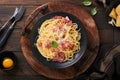 Carbonara pasta. Spaghetti with pancetta, egg, parmesan cheese and cream sauce on old dark black wooden table background. Royalty Free Stock Photo