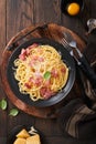 Carbonara pasta. Spaghetti with pancetta, egg, parmesan cheese and cream sauce on old dark black wooden table background. Royalty Free Stock Photo