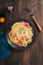 Carbonara pasta. Spaghetti with pancetta, egg, parmesan cheese and cream sauce on old dark black wooden table background. Royalty Free Stock Photo