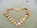 Card background shells on the beach top view heart shape next to the ocean