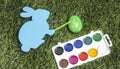 Card bunny with marker on it`s hand, painting egg into green. Royalty Free Stock Photo
