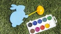 Card bunny with marker on it`s hand, painting egg into yellow. Royalty Free Stock Photo