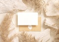 Card and enveelope near beige travertine stones and dried pampas grass top view, mockup Royalty Free Stock Photo