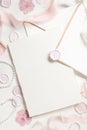 Card and envelope near pink decorations, seals and silk ribbons on white table top view, wedding mockup Royalty Free Stock Photo