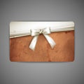 Card with grunge cardboard texture and a white bow Royalty Free Stock Photo