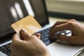 Card in hand and entering security code using laptop keyboard. Royalty Free Stock Photo