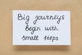 Card with phrase Big Journeys Begin With Small Steps on beige background, top view. Motivational quote Royalty Free Stock Photo