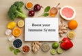 Card with phrase Boost Your Immune System and fresh products on wooden table, flat lay