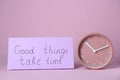 Card with phrase Good Things Take Time and clock on pink background. Motivational quote