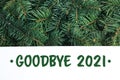 Card with phrase Goodbye 2021 on Christmas tree branches, top view