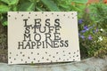 Card with phrase Less Stuff More Happiness on stone planter outdoors Royalty Free Stock Photo