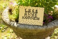 Card with phrase Less Stuff More Happiness on stone planter outdoors Royalty Free Stock Photo