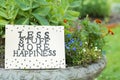 Card with phrase Less Stuff More Happiness on stone planter outdoors Royalty Free Stock Photo