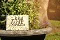 Card with phrase Less Stuff More Happiness on stone planter outdoors, space for text Royalty Free Stock Photo