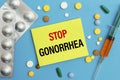 Card with text Stop Gonorrhea, pills and syringe