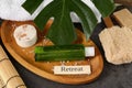 Card with word Retreat, different spa products and green palm leaf on textured table