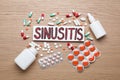 Card with word Sinusitis, drops, nasal spray and pills on wooden table, flat lay