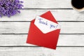 Thank you card and envelope on wooden background